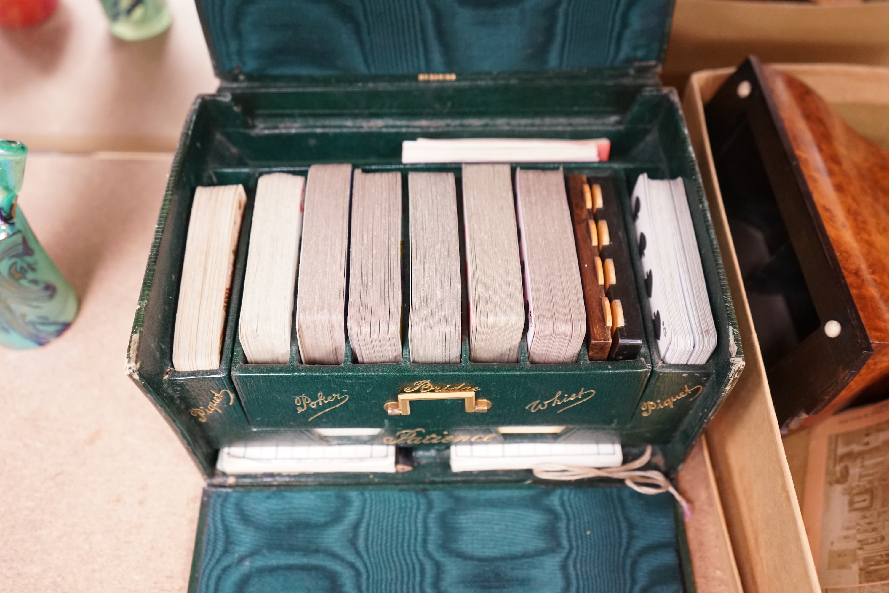 A Cook's patent stereoscope viewer and viewing cards together with a green Morocco leather playing cards box, box 12.5cm high x 24cm wide. Condition, games box poor, viewer and cards good